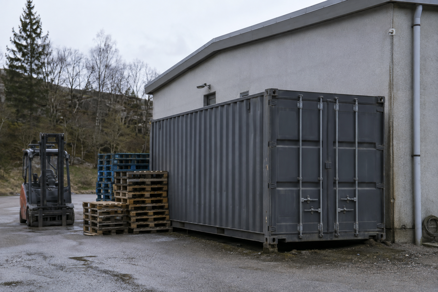 Containerlager med paller og gaffeltruck mellem containerrækkerne