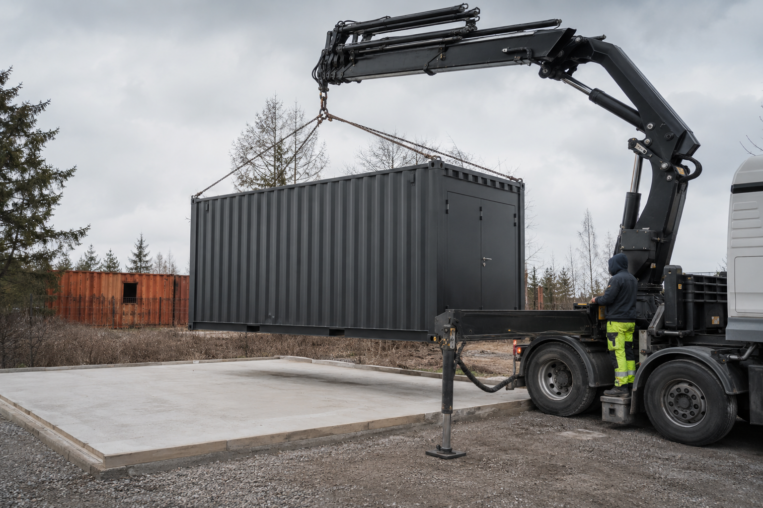 Kranbil sænker container på klargjort grund